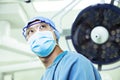 Low angle view of surgeon wearing a surgical mask and glasses in the operating room