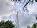 Low Angle View of Telecommunication Tower Through Tree Canopy Against Cloudy Sky Royalty Free Stock Photo