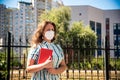 Low angle view of teacher with face mask after lockdown, walking in front of school waiting for children. New normal lifestyle Royalty Free Stock Photo