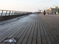 Low angle view of Tel Aviv port wooden boardwalk at sunset with people walking in the distance