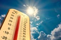 Thermometer on blue sky with sun shining in summer show higher Weather