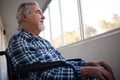 Low angle view of thoughtful senior man sitting on wheelchair Royalty Free Stock Photo