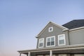 Low angle view of a traditional home with gray vinyl wall siding