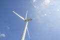 Low angle view of wind turbine against partly cloudy blue sky Royalty Free Stock Photo