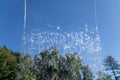 Low angle view from under a fountain over a the blue sky and nature, water curtain, rain in first plan Royalty Free Stock Photo