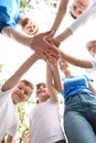 Low angle view of volunteers with kids joining hands Royalty Free Stock Photo