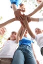 Low angle view of volunteers with kids joining hands Royalty Free Stock Photo