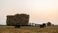 Low-angle view of a walk-behind tractor carrying piles of straw bales Royalty Free Stock Photo