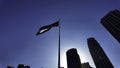 Low angle view of a waving flag against blue sky. Action. Dubai, UAE, architecture and waving flag. Royalty Free Stock Photo