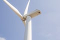 Low angle view of wind turbine against partly cloudy blue sky Royalty Free Stock Photo