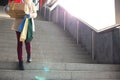 Low angle view of woman with gifts and shopping bags moving down steps