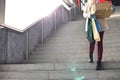 Low angle view of woman with gifts and shopping bags moving down steps