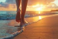 Low angle view of womans feet walking on a sandy beach on sunset Royalty Free Stock Photo