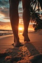 Low angle view of womans feet walking on a sandy beach on sunset Royalty Free Stock Photo