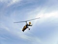 Low angle view of yellow color Gyrocopter flying in the blue sky and dramatic clouds, fun fly, aero sports, skydive, Roto craft,