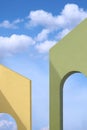 Low angle view of yellow and green Tuscan arch walls against white clouds on blue sky Royalty Free Stock Photo