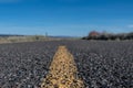 Low Angle View of Yellow Stripe on Rough Desert Road Royalty Free Stock Photo