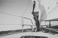 Low angle view of young bearded man standing on the yacht in sunny day. Horizontal black and white mockup Royalty Free Stock Photo