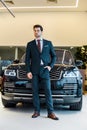 low angle view of young businessman in eyeglasses posing near car Royalty Free Stock Photo