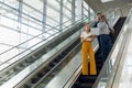 Young business people going down an escalator in a modern building Royalty Free Stock Photo