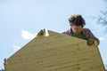 Low angle view of a young man assembling a wooden playhouse Royalty Free Stock Photo