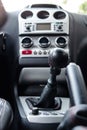 Low angle wide view of generic car middle console dashboard visible manual gearbox lever