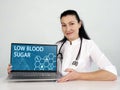 LOW BLOOD SUGAR Hypoglycemia text in menu. Podiatrist looking for something at laptop