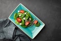 Low-calorie spinach and tomato salad in a stylish plate.