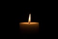 Candle burns at dusk, a candle fire on a black background Royalty Free Stock Photo