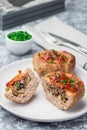 Low carb paleo meat cups, stuffed with champignons, bacon and cheese, garnished with green onion, on plate, vertical