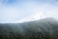 Low clouds hovering over mountain ridge and snow covered peaks. Natural background Royalty Free Stock Photo