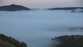 Low clouds in the mountains filled the entire valley and mountain peaks and hills stick out above the clouds Royalty Free Stock Photo