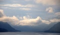 Low clouds before the rain descend from the mountains to the surface of a mountain lake Royalty Free Stock Photo