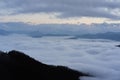 Low clouds, view of winter forest and mountains from observation deck, horizontal picture of amazing natural phenomenon. Beautiful Royalty Free Stock Photo