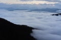 Low clouds, view of winter forest and mountains from observation deck, horizontal picture of amazing natural phenomenon. Beautiful Royalty Free Stock Photo