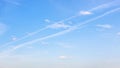 Low contrail and little cumuli clouds in blue sky