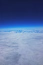 Low earth orbit - View of white clouds and mountains during the flight to the low orbit of the Earth, at the top of the blue sky Royalty Free Stock Photo