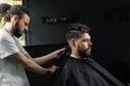 Low fade machine haircut for handsome bearded man in barbershop. Barber with dread locks making hairstyle with a smooth Royalty Free Stock Photo