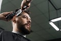 Low fade machine haircut for handsome bearded man in barbershop. Barber with dread locks making hairstyle with a smooth Royalty Free Stock Photo