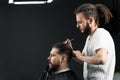 Low fade machine haircut for handsome bearded man in barbershop. Barber with dread locks making hairstyle with a smooth Royalty Free Stock Photo