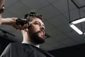 Low fade machine haircut for handsome bearded man in barbershop. Barber with dread locks making hairstyle with a smooth Royalty Free Stock Photo