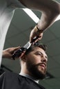 Low fade machine haircut for handsome bearded man in barbershop. Barber with dread locks making hairstyle with a smooth Royalty Free Stock Photo