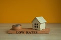 Low house rates symbol. Concept red words \'Low rates\' on brick block near miniature houses.