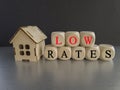 Low house rates symbol. Concept red words \'Low rates\' on wooden cubes near miniature houses. Royalty Free Stock Photo