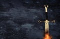 low key banner of silver sword in the flames of fire. fantasy medieval period. Royalty Free Stock Photo