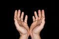 Low key, close up of hands of a faithful mature man praying, hands folded, interlaced fingers in worship to god