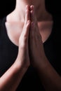 Low key, close up of hands of a faithful woman praying, with hands folded and palms together Royalty Free Stock Photo