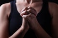 Low key, close up of hands of a faithful woman praying Royalty Free Stock Photo