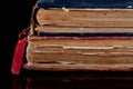 Low key closeup of very old books in poor condition on black background. Royalty Free Stock Photo