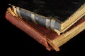 Low key closeup of very old books in poor condition on black background. Royalty Free Stock Photo